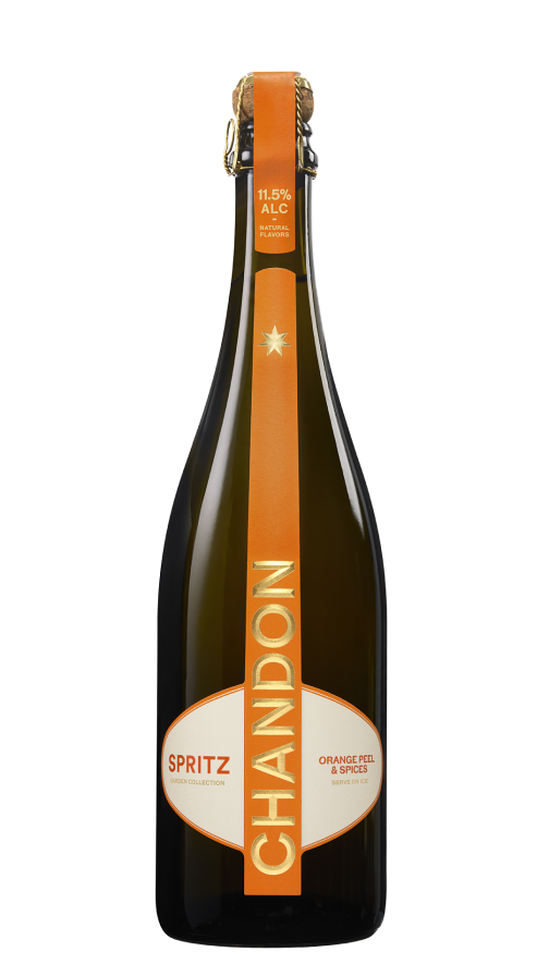 Chandon Spritz Flasche und ein Glas Chandon Spritz, garniert mit einer Orangenscheibe und Rosmarin, vor dem Hintergrund einer sonnigen Stadtlandschaft.